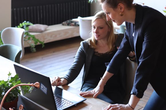Two women locking at lap top